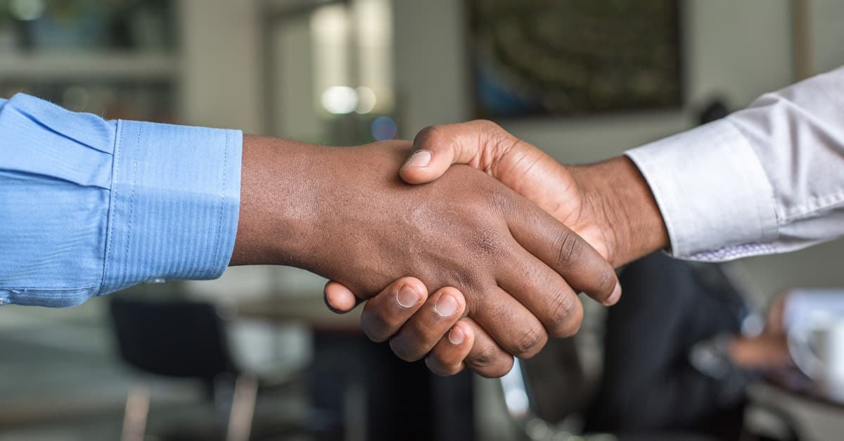 Close-up photo of two men shaking hands.